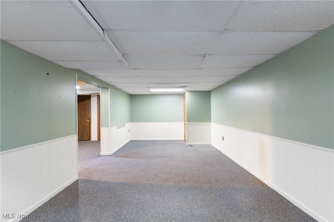 302 Poplar Avenue Northwest Canton, OH 44708 - Photo 27 of 34 Finished below grade area featuring wainscoting, a paneled ceiling, and carpet flooring