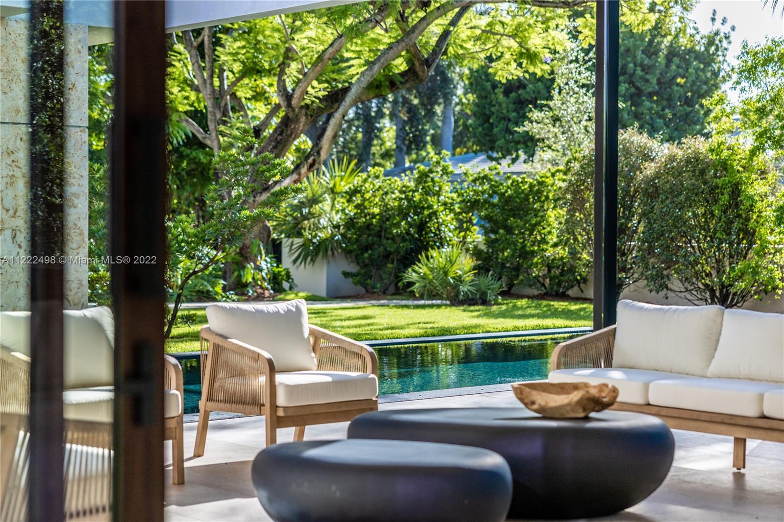 4550 Bay Point Road Miami, FL 33137 - Photo 41 of 92 a view of a patio with couches and a table and chairs with wooden floor and fence