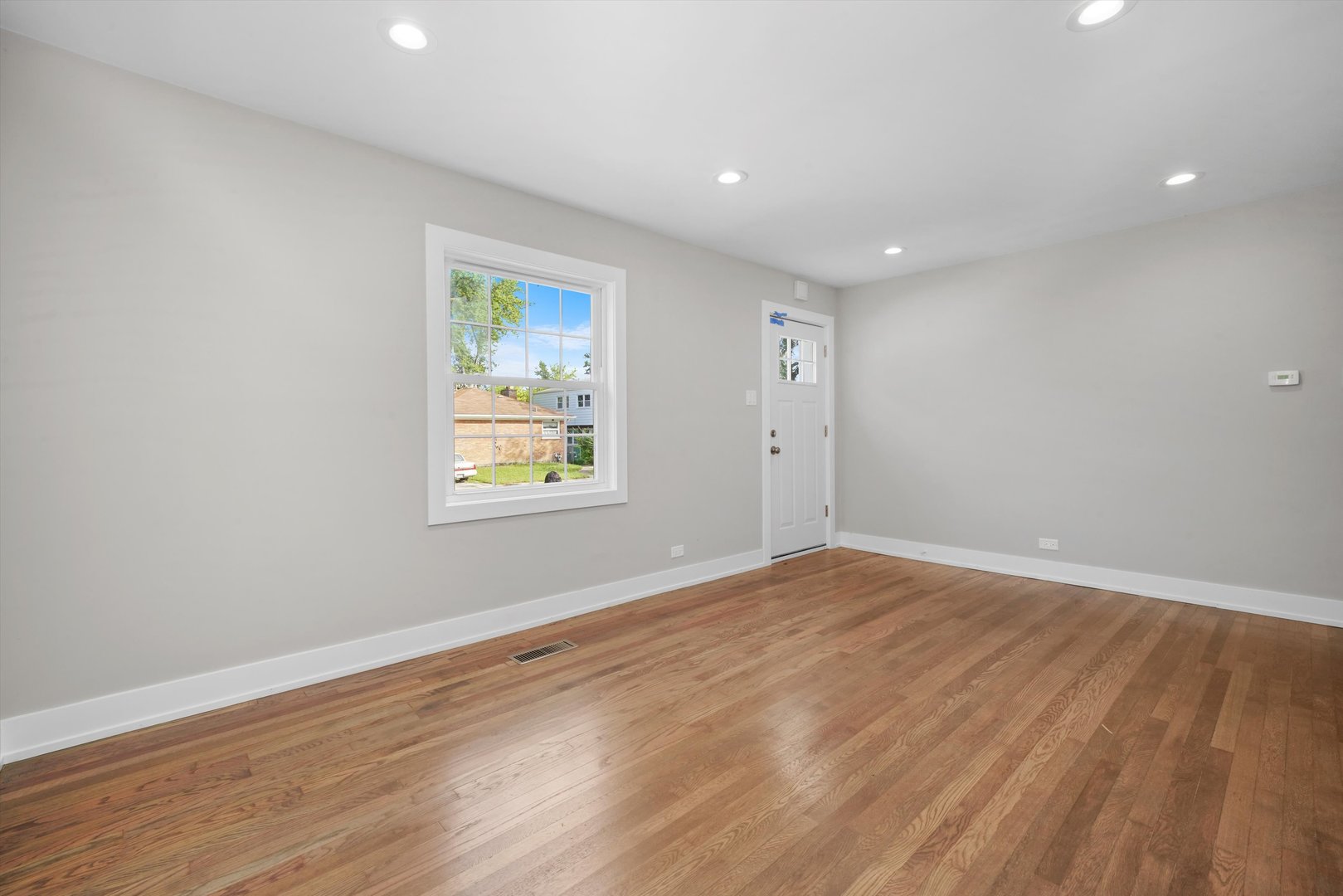 329 East Quincy Street Riverside, IL 60546 - Photo 7 of 39 a view of an empty room with wooden floor and a window