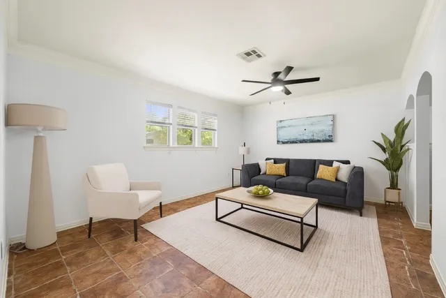 a living room with furniture a chandelier fan and a rug