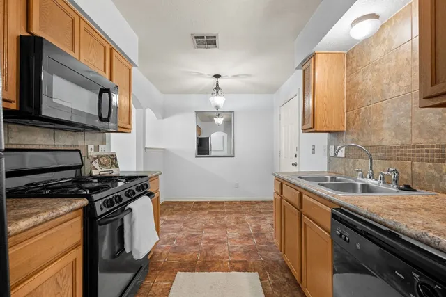 a kitchen with stainless steel appliances granite countertop a sink stove oven and granite counter tops