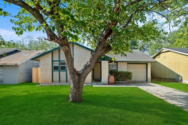 a front view of house with a garden and yard