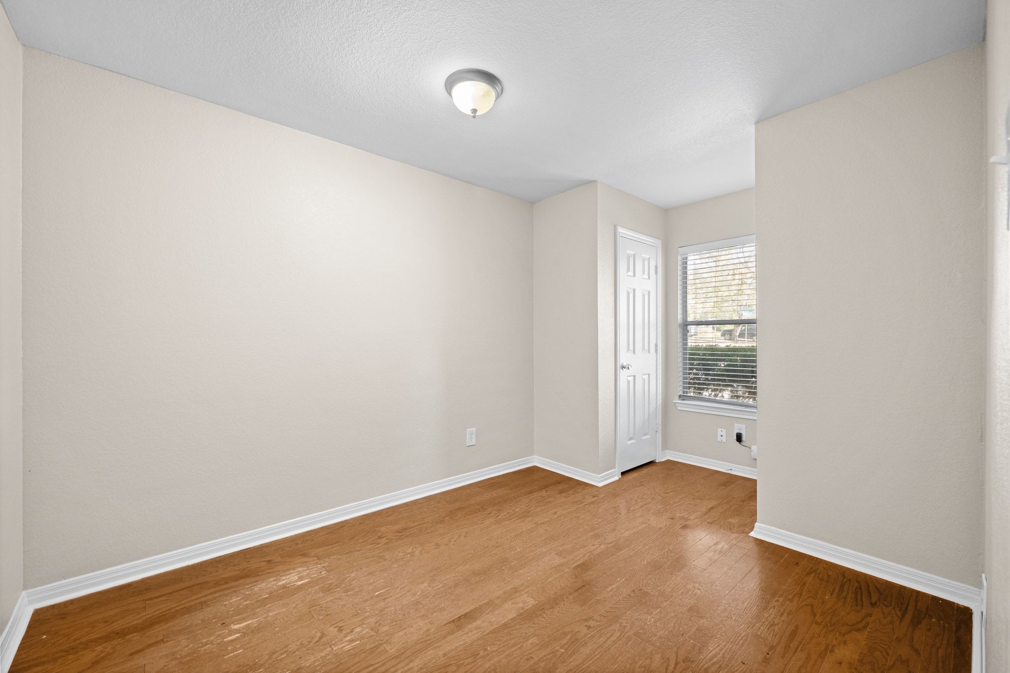 2321 Bendridge Trail Austin, TX 78744 - Photo 23 of 27 an empty room with wooden floor and windows