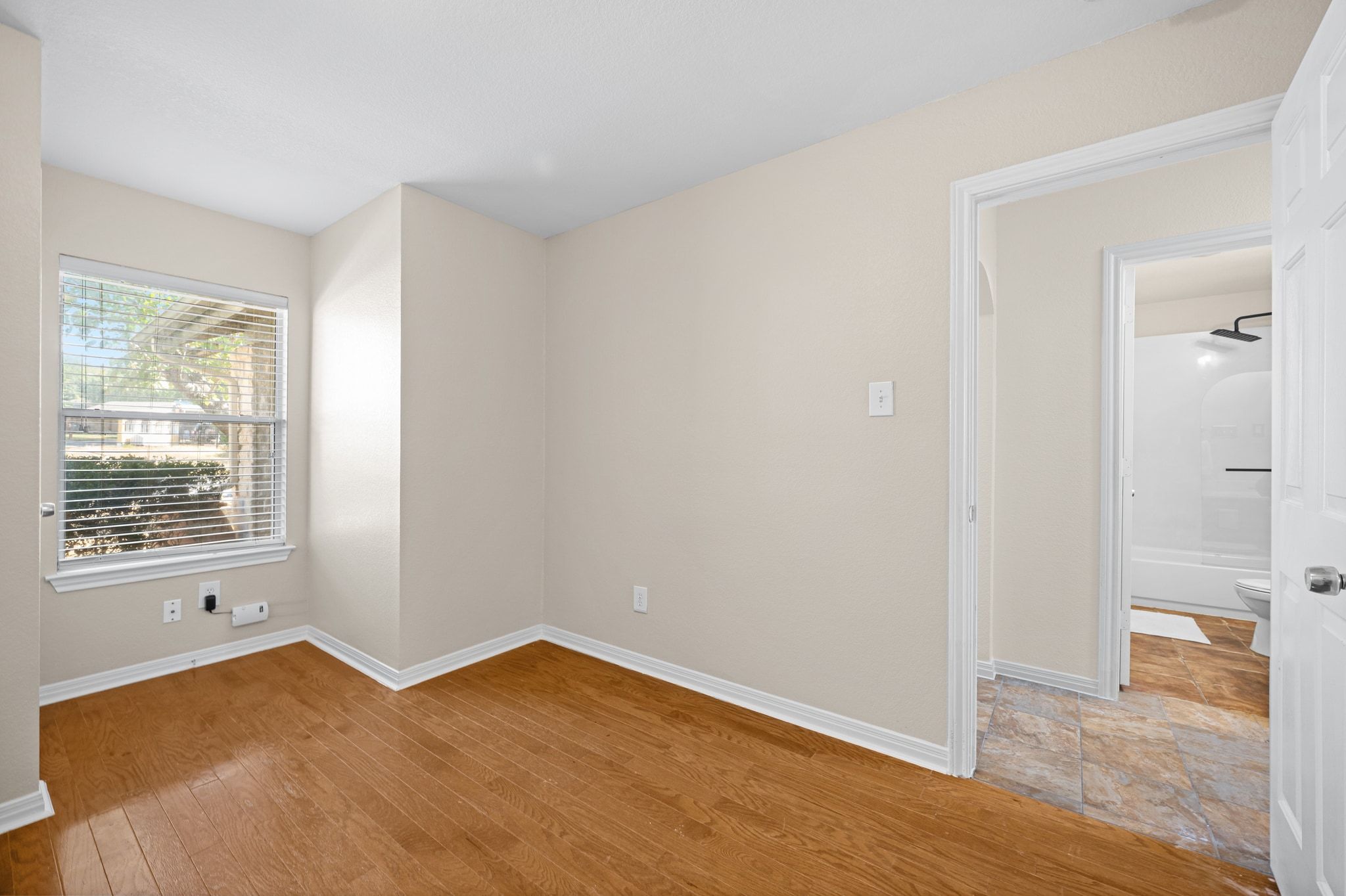 2321 Bendridge Trail Austin, TX 78744 - Photo 24 of 27 a view of an empty room with wooden floor and a window