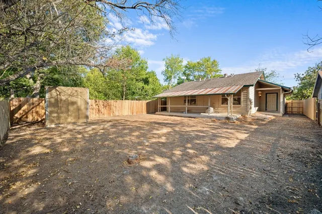 a view of a house with backyard and trees