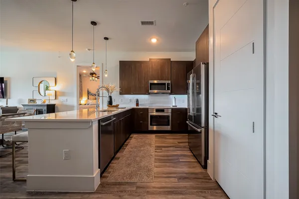 a large kitchen with stainless steel appliances kitchen island granite countertop a stove a refrigerator and a sink