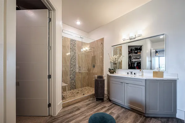 a bathroom with a double vanity sink toilet and shower
