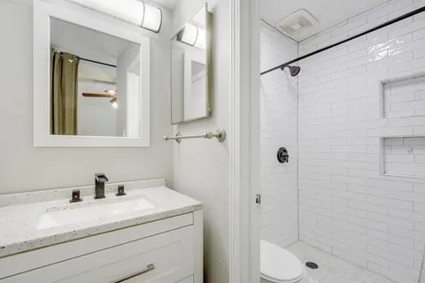 a bathroom with a granite countertop sink toilet and shower