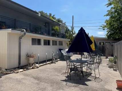 a view of a patio with table and chairs under an umbrella