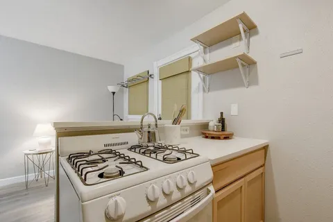 a stove top oven sitting inside of a kitchen