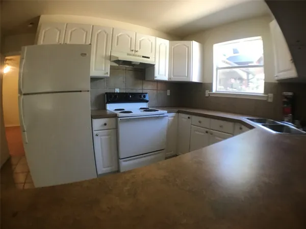 a kitchen with granite countertop a sink stainless steel appliances and cabinets