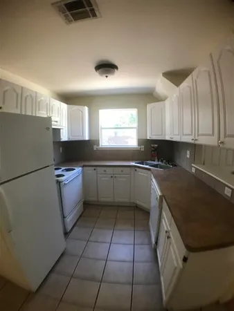 a kitchen with a sink a stove a refrigerator and cabinets