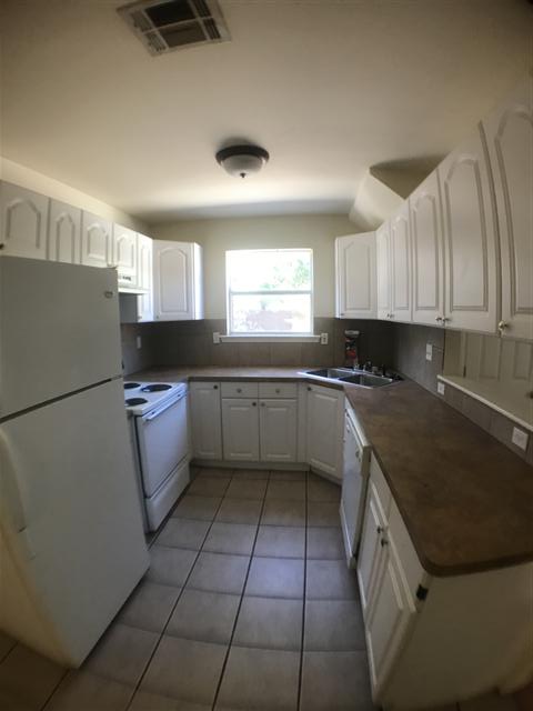5603 Joe Sayers Avenue, Unit A Austin, TX 78756 - Photo 4 of 11 a kitchen with a sink a stove a refrigerator and cabinets