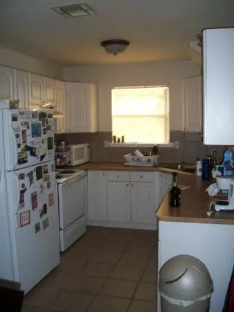 a kitchen with stainless steel appliances a sink a stove a refrigerator and cabinets