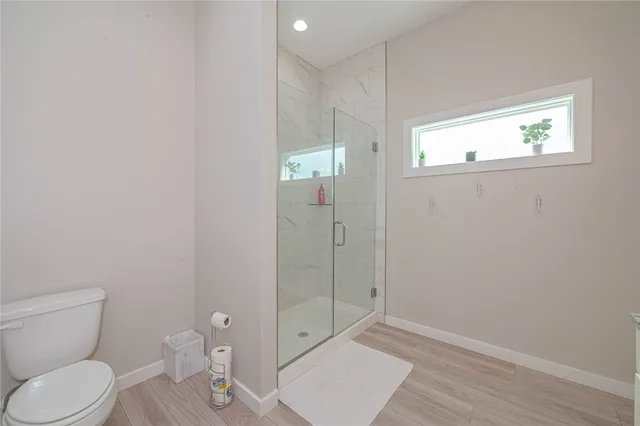a bathroom with a granite countertop toilet and a shower