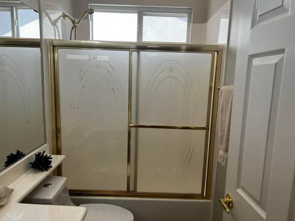 a bathroom with a sink a toilet a mirror and shower