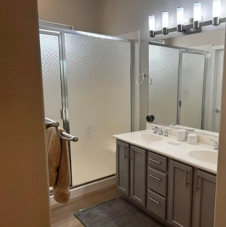 a bathroom with a granite countertop sink mirror and shower
