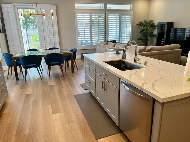 a kitchen with stainless steel appliances a sink a counter top space and a large window
