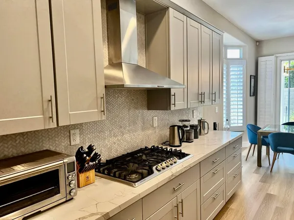 a kitchen with stainless steel appliances a stove a sink and a refrigerator with wooden floor