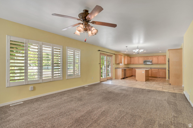 546 Wheatridge Road Tooele, UT 84074 - Photo 11 of 49 Open-concept area featuring a kitchen with wood cabinetry, a central island, and tile flooring