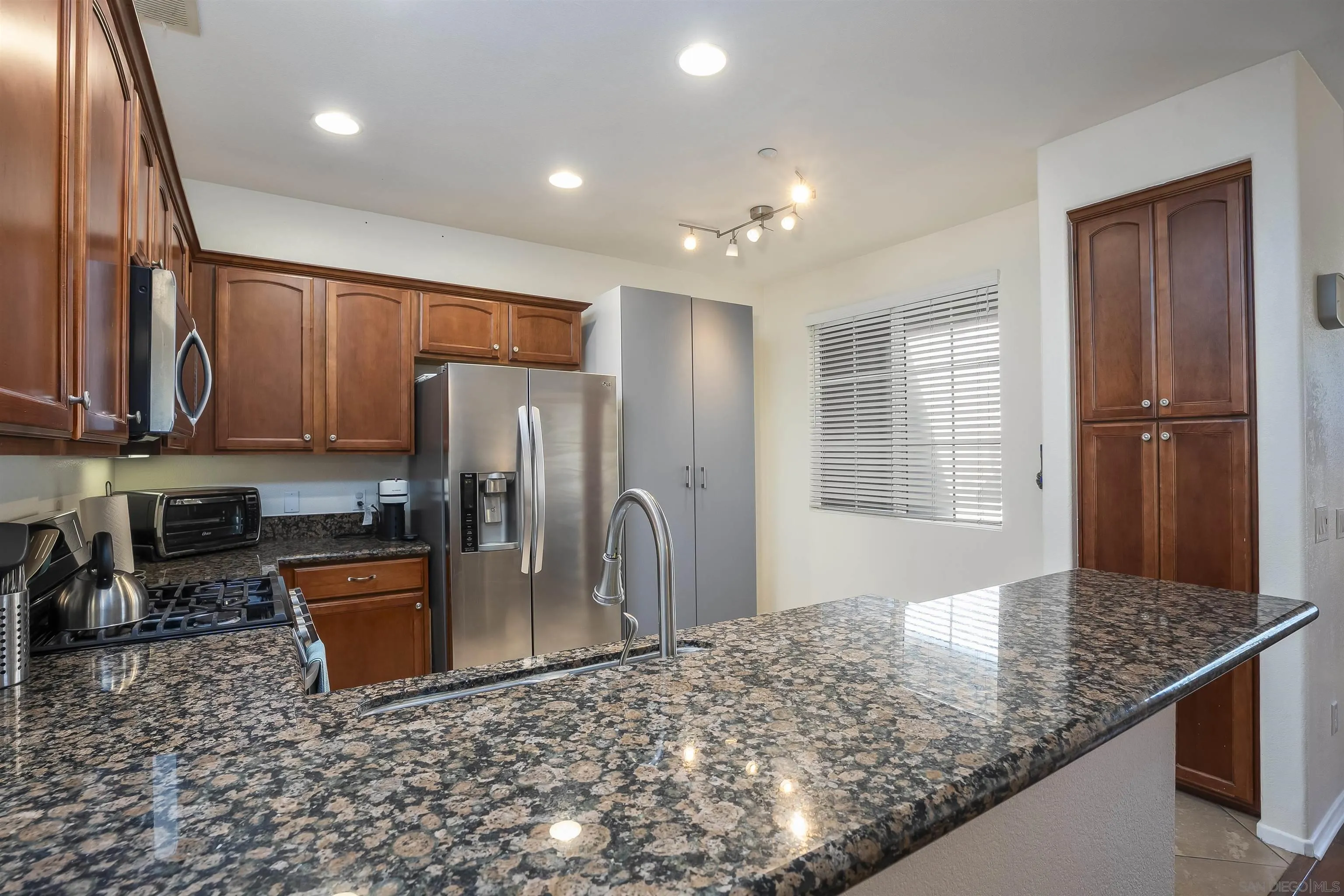 289 Reef Point Way, Unit 3 Oceanside, CA 92058 - Photo 9 of 23 a kitchen with stainless steel appliances granite countertop a sink stove and refrigerator