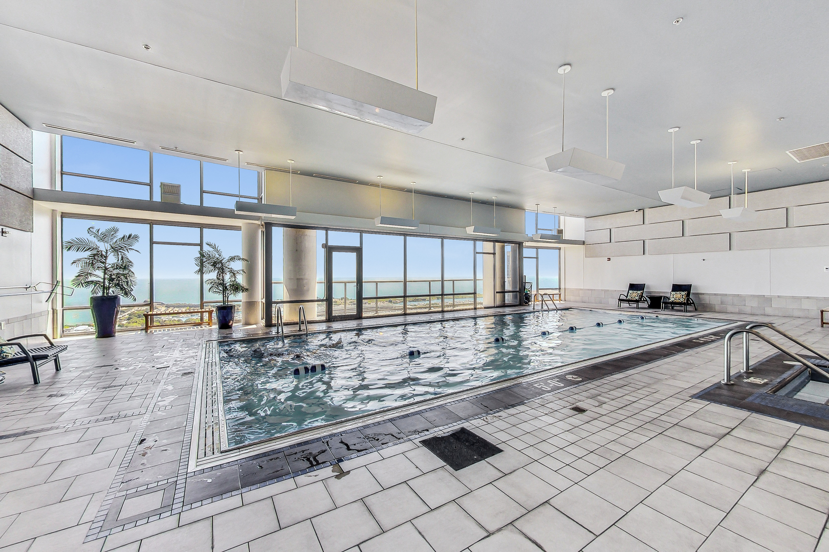 100 East 14th Street, Unit 2010 Chicago, IL 60605 - Photo 28 of 30 a large white kitchen with kitchen island granite countertop a large window and a sink