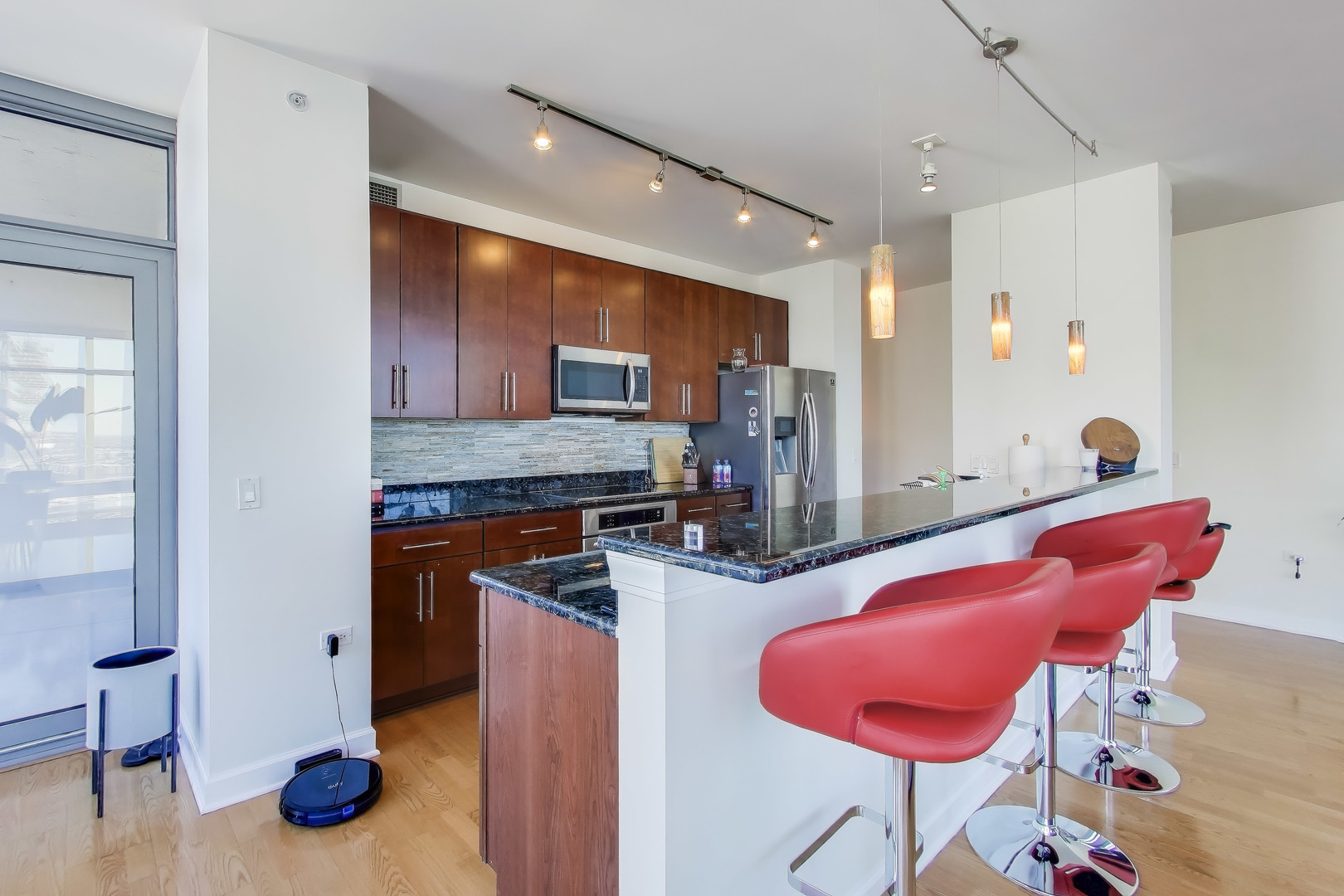 100 East 14th Street, Unit 2010 Chicago, IL 60605 - Photo 9 of 30 a kitchen with stainless steel appliances kitchen island granite countertop a refrigerator and a sink