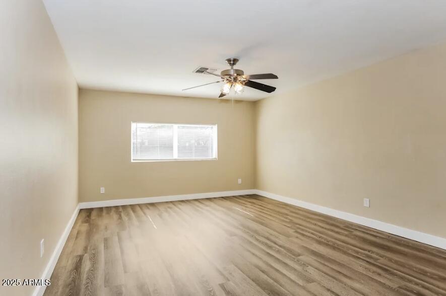 7129 West Merrell Street Phoenix, AZ 85033 - Photo 3 of 6 a view of an empty room with wooden floor and a window
