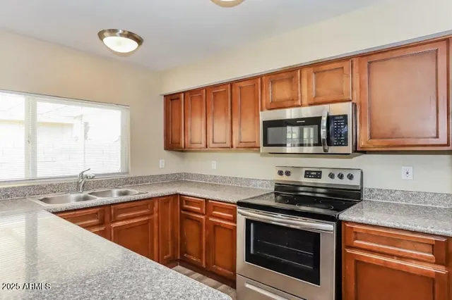 a kitchen with stainless steel appliances granite countertop a sink stove and microwave