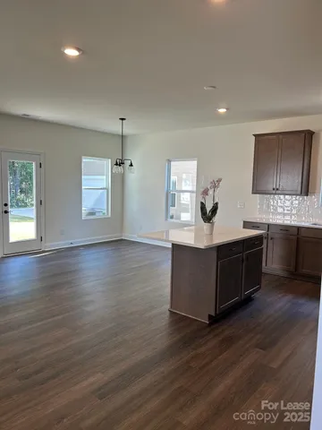 a kitchen with stainless steel appliances kitchen island wooden cabinets and entryway