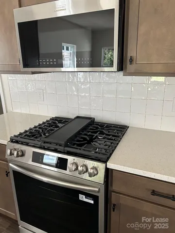 a stove top oven sitting inside of a kitchen
