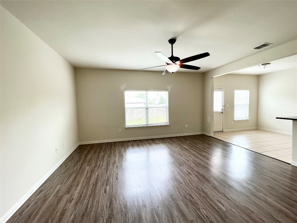 108 Major Lee Lane Jarrell, TX 76537 - Photo 2 of 15 an empty room with wooden floor chandelier fan and windows