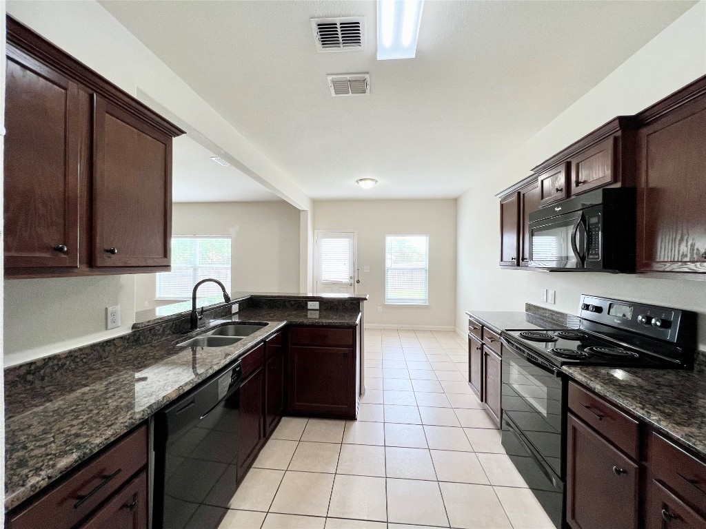 108 Major Lee Lane Jarrell, TX 76537 - Photo 3 of 15 a kitchen with stainless steel appliances granite countertop a sink stove and oven