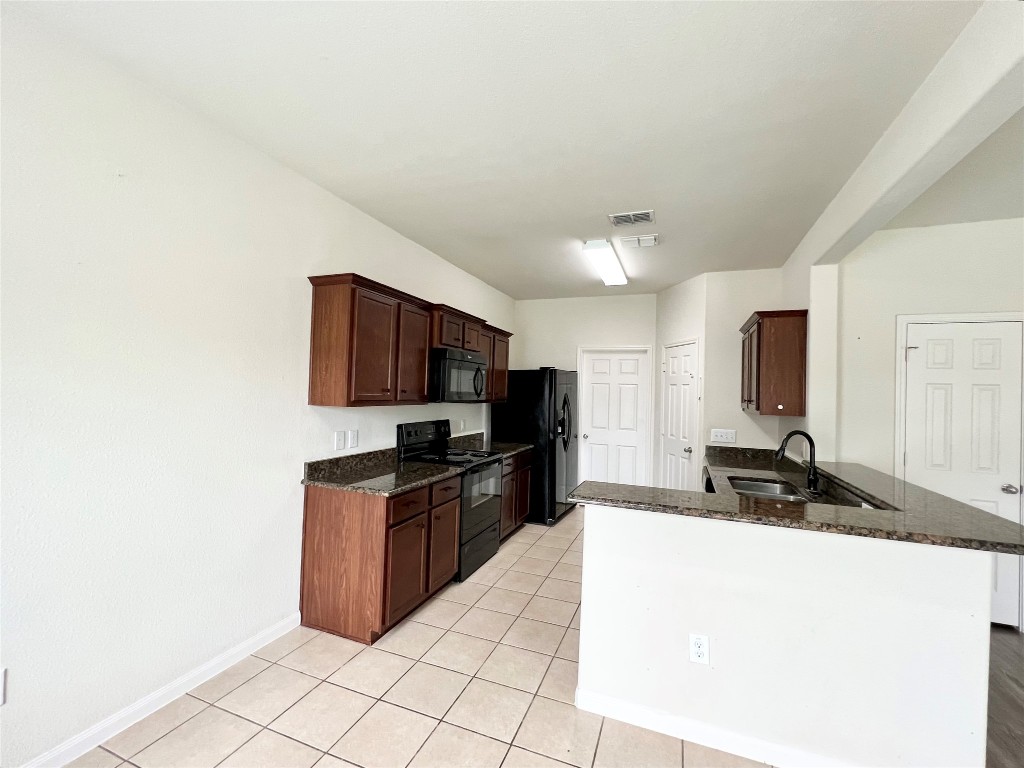 108 Major Lee Lane Jarrell, TX 76537 - Photo 4 of 15 a kitchen with granite countertop a sink a stove top oven a granite counter space and cabinets