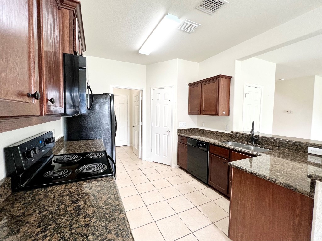 108 Major Lee Lane Jarrell, TX 76537 - Photo 7 of 15 a kitchen with granite countertop a stove and a sink