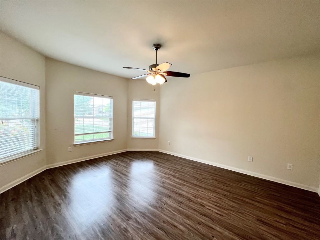 108 Major Lee Lane Jarrell, TX 76537 - Photo 9 of 15 an empty room with wooden floor chandelier fan and windows