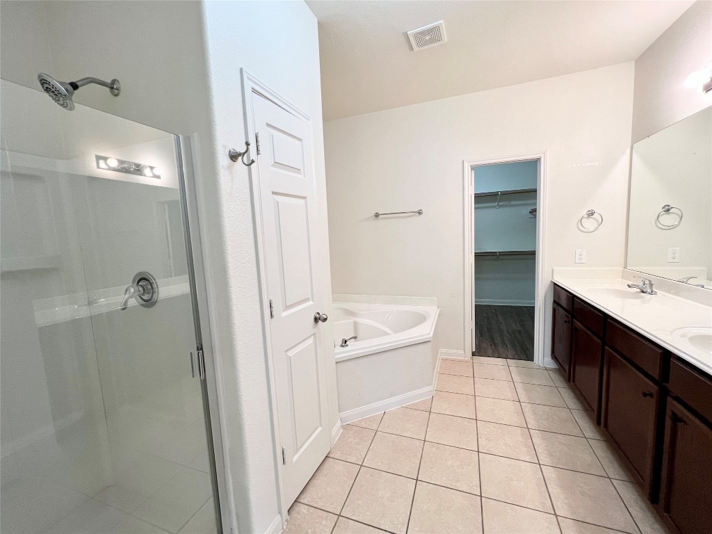 108 Major Lee Lane Jarrell, TX 76537 - Photo 10 of 15 a spacious bathroom with a granite countertop sink a mirror and a bathtub