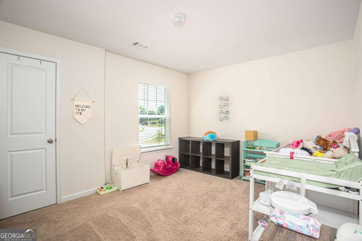 653 Meadows Farm Way Monroe, GA 30655 - Photo 27 of 34 a bedroom with a bed and a dresser