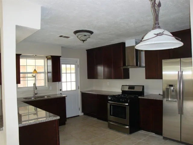 a kitchen with stainless steel appliances a sink a stove and a refrigerator