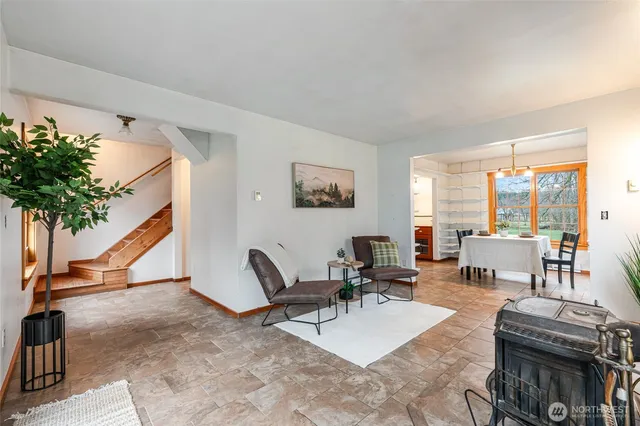 a living room with furniture a potted plant and a large window
