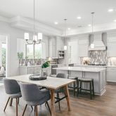 a kitchen with kitchen island granite countertop a table and chairs in it
