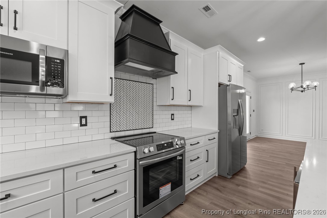 296 Persimmon Tree Drive Cameron, NC 28326 - Photo 11 of 43 a kitchen with stainless steel appliances white cabinets a stove a sink and a microwave