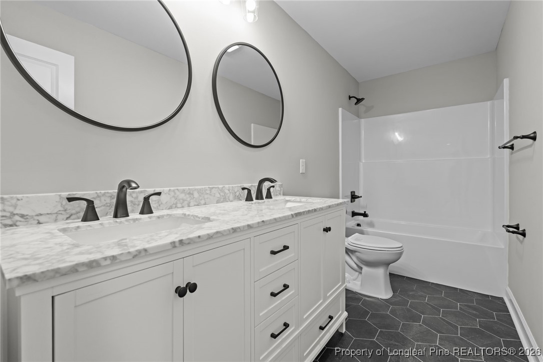 296 Persimmon Tree Drive Cameron, NC 28326 - Photo 25 of 43 a bathroom with a granite countertop toilet a sink and a mirror