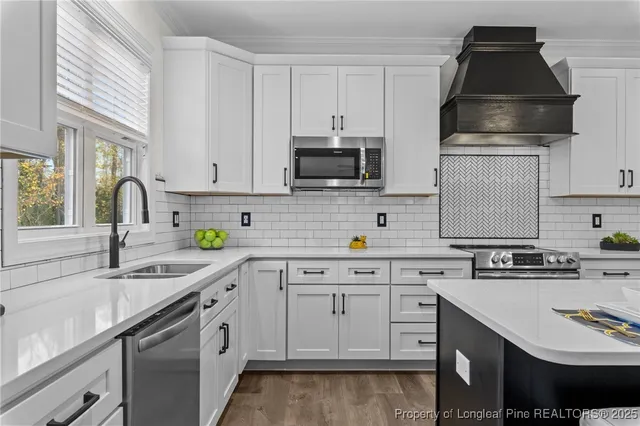 a kitchen with white cabinets and appliances