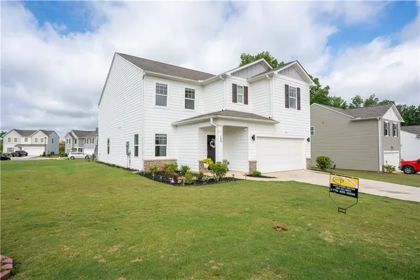 a front view of a house with a garden and yard