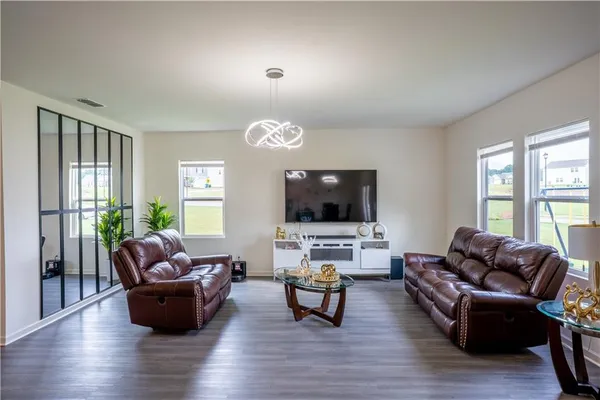 a living room with furniture flat screen tv and a large window