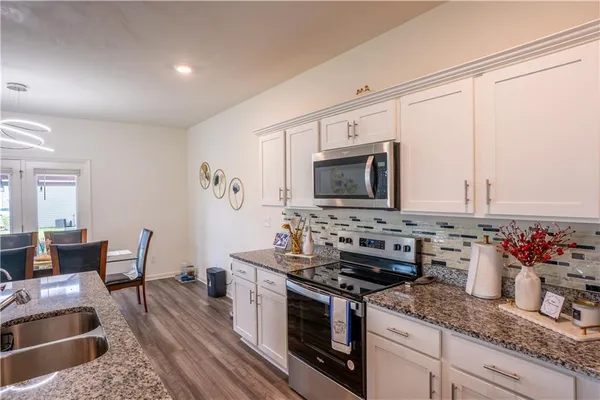 a kitchen with stainless steel appliances granite countertop a stove a sink and a microwave