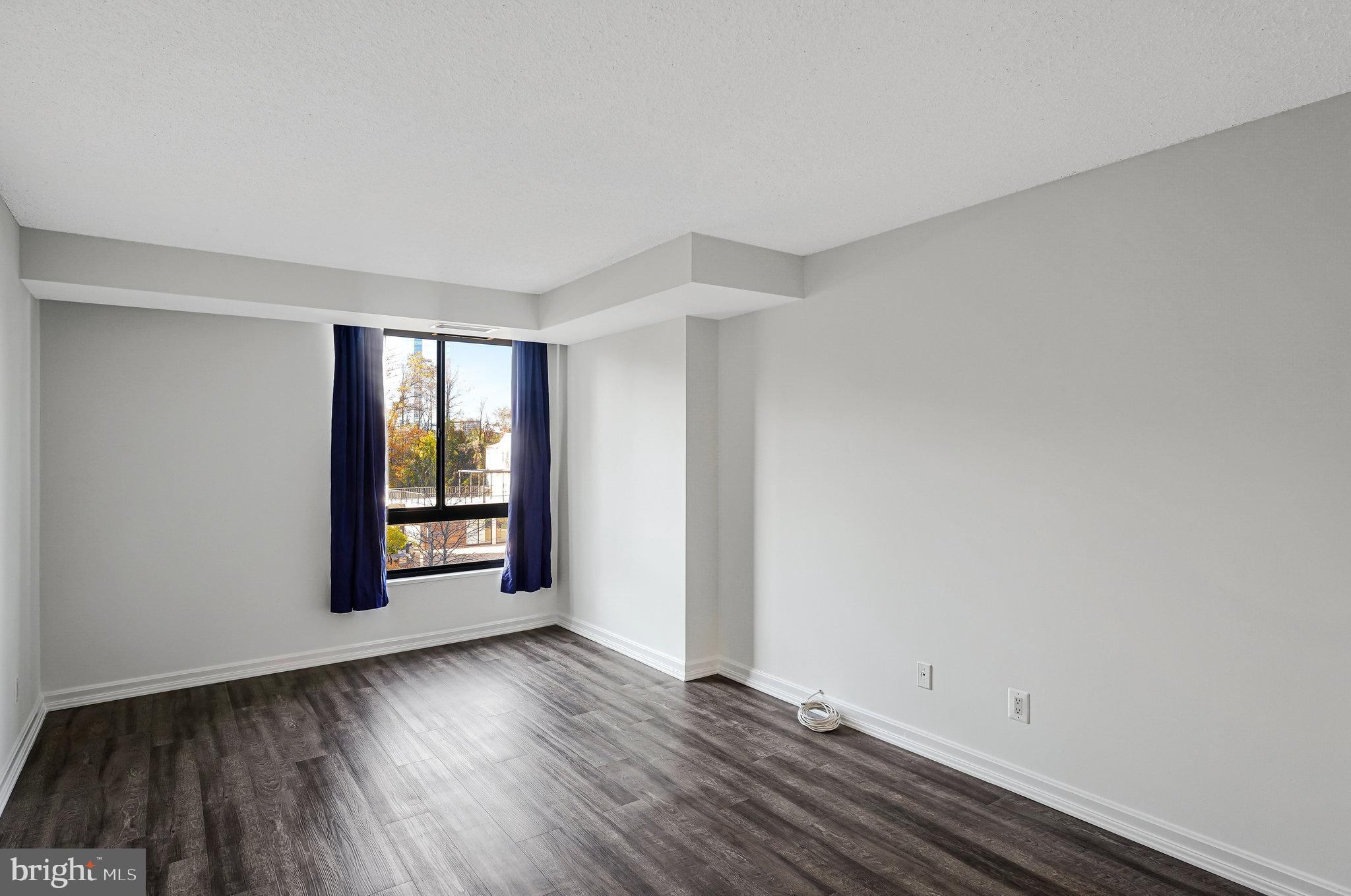 1800 Old Meadow Road, Unit 302 McLean, VA 22102 - Photo 12 of 35 a view of an empty room with wooden floor and a window