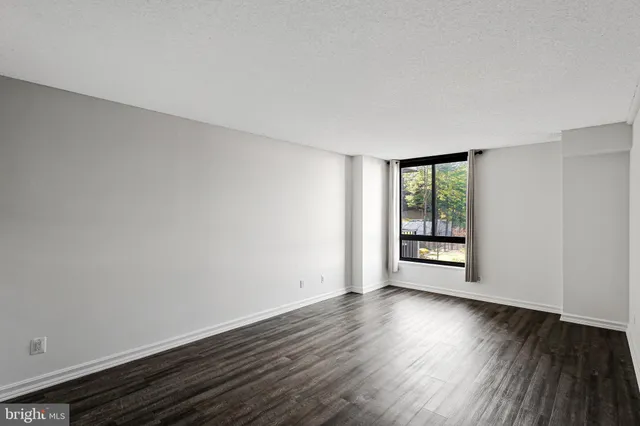 a view of empty room with wooden floor and cabinets