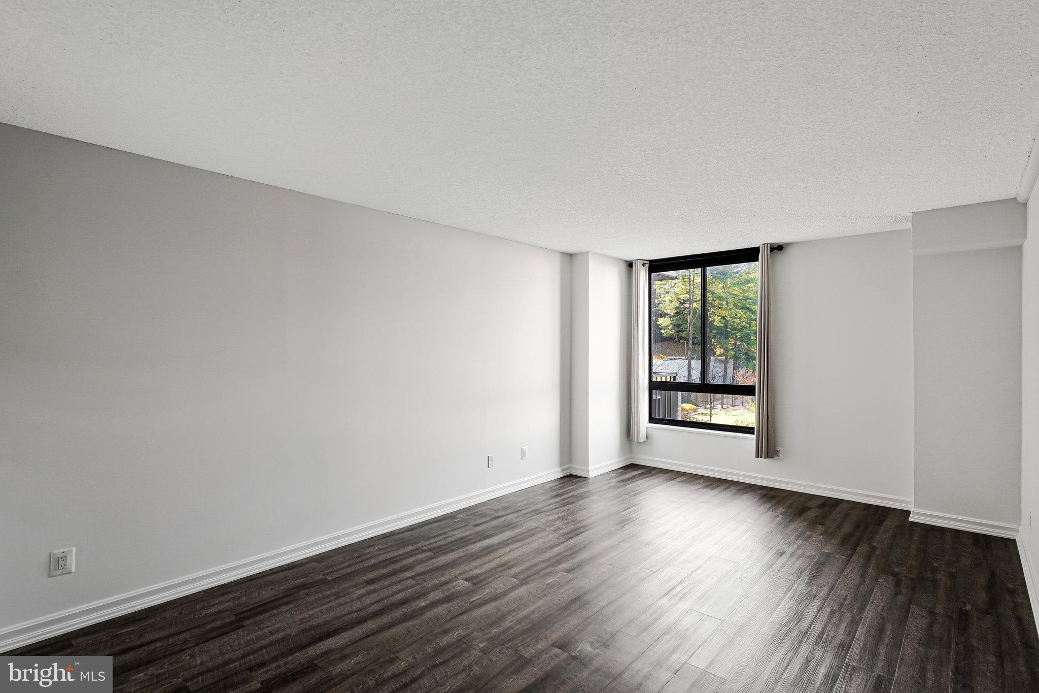 1800 Old Meadow Road, Unit 302 McLean, VA 22102 - Photo 16 of 35 a view of an empty room with wooden floor and a window